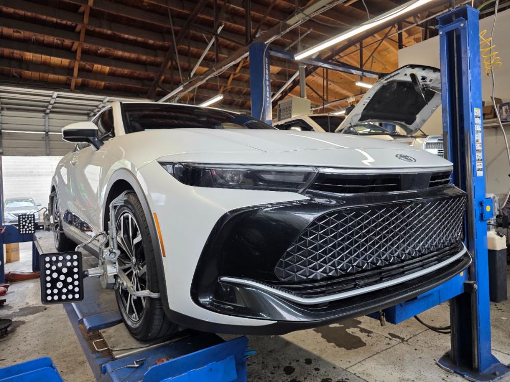 A new Toyota on the shop's lift with wheel alignment targets attached